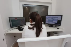 medica delante de unos ordenadores controlando la duraci&oacute;n de una resonancia magn&eacute;tica